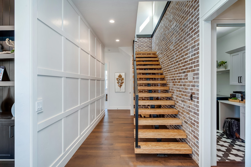 Design ideas for a mid-sized transitional wood straight staircase in Boise with open risers and metal railing.