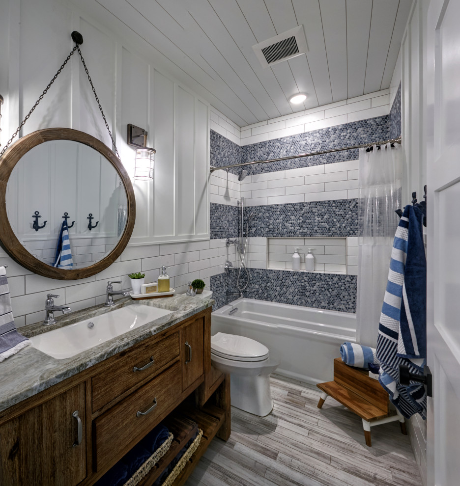 Photo of a mid-sized beach style 3/4 bathroom in Other with flat-panel cabinets, dark wood cabinets, an alcove tub, a shower/bathtub combo, multi-coloured tile, white walls, an undermount sink, beige floor, a shower curtain, grey benchtops, a single vanity, a freestanding vanity, timber, panelled walls, a two-piece toilet, glass sheet wall, cement tiles, granite benchtops and a niche.