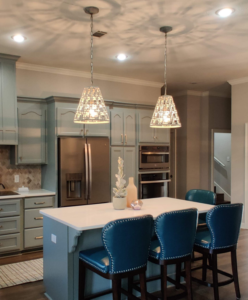 Mid-sized transitional l-shaped dark wood floor and brown floor eat-in kitchen photo in Little Rock with an undermount sink, green cabinets, quartz countertops, beige backsplash, marble backsplash, stainless steel appliances, an island and white countertops