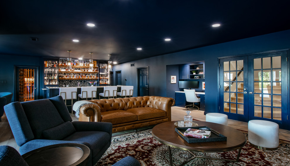 Immagine di una grande taverna chic con angolo bar, pareti blu, pavimento in legno massello medio e pavimento marrone
