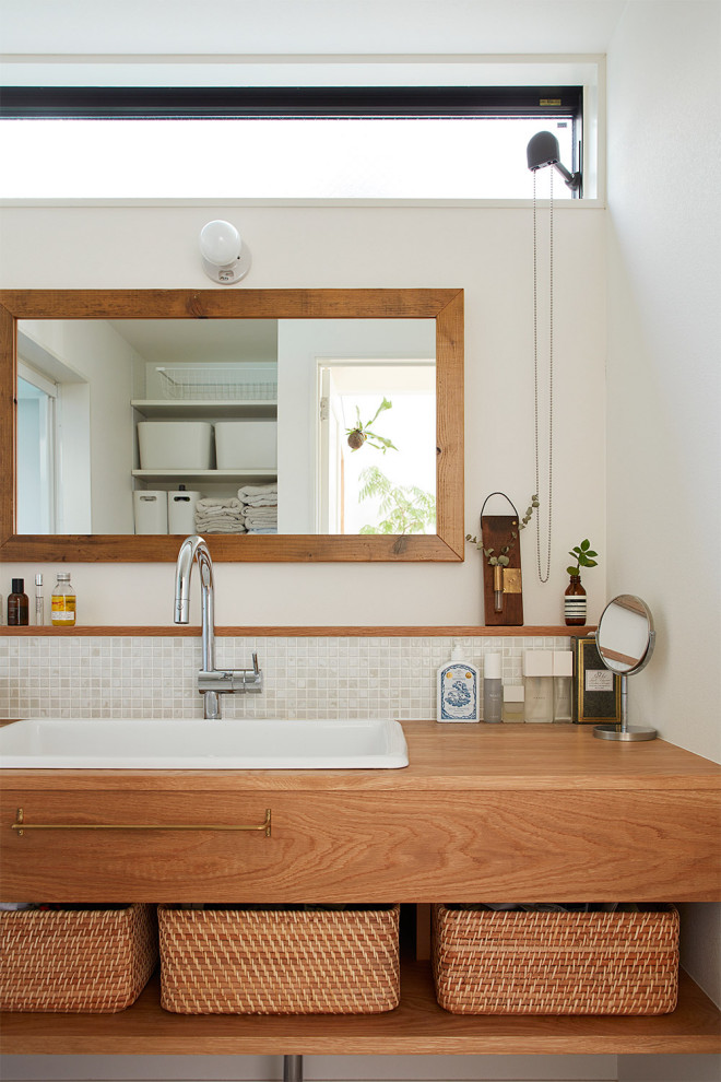 На фото: туалет в скандинавском стиле с плиткой кабанчик и столешницей из дерева с
