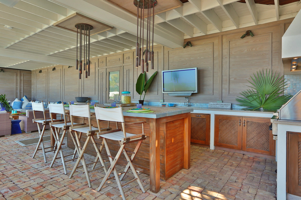 Inspiration for a tropical patio in Tampa with an outdoor kitchen, brick pavers and a roof extension.