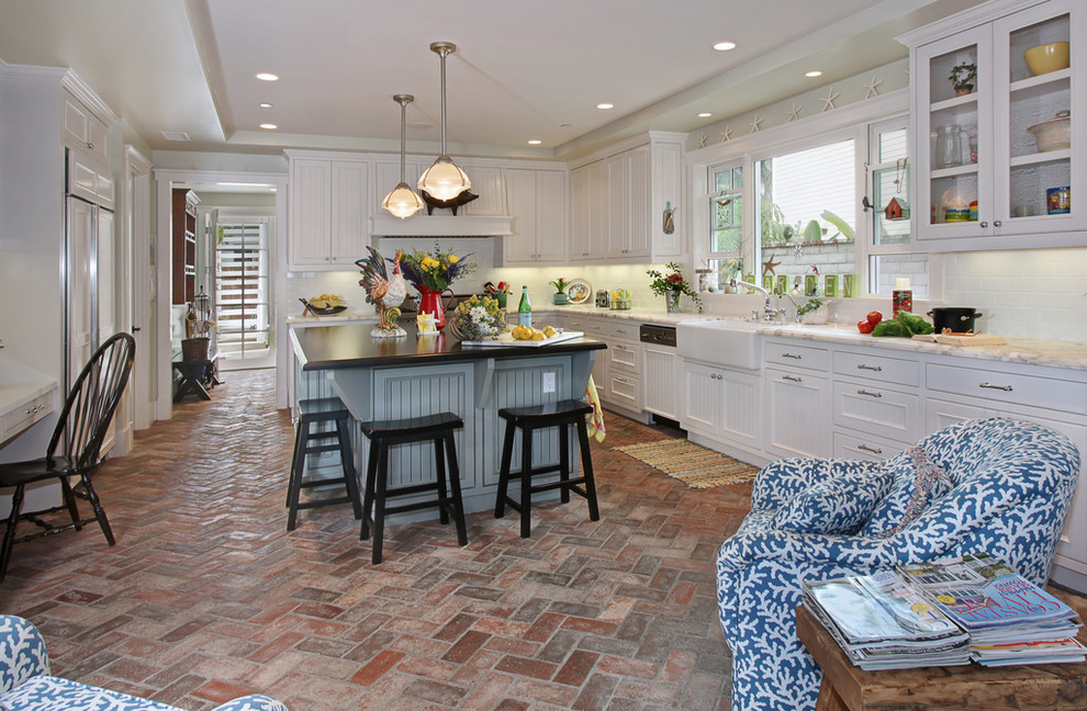 Photo of a beach style kitchen in Orange County with a farmhouse sink and brick floors.