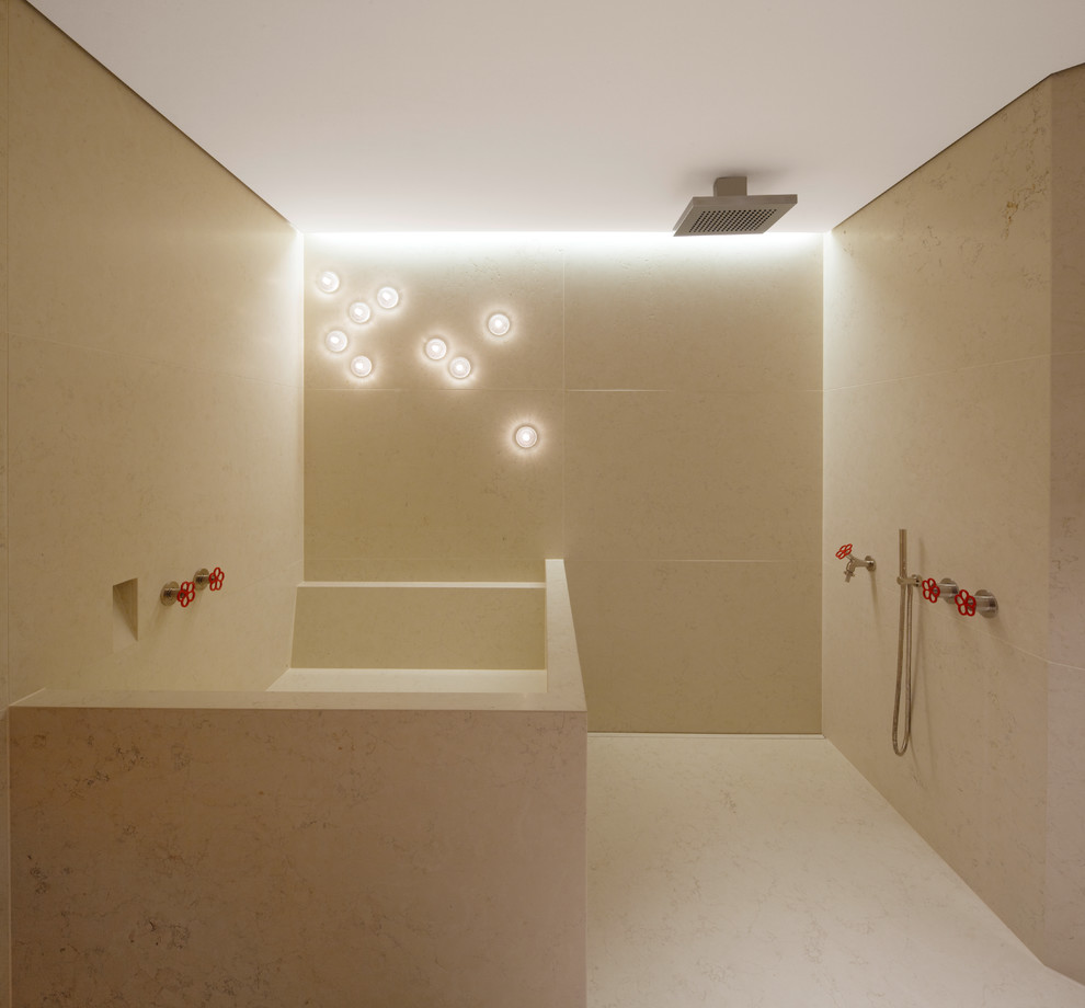 Inspiration for a mid-sized contemporary bathroom in Frankfurt with a drop-in tub, an open shower, beige tile, stone tile, beige walls, limestone floors and an open shower.