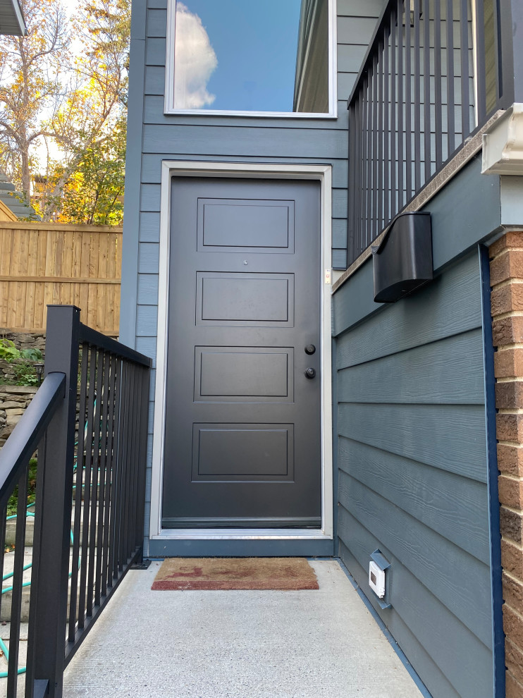 This is an example of a traditional front door in Calgary with blue walls, a single front door and a gray front door.