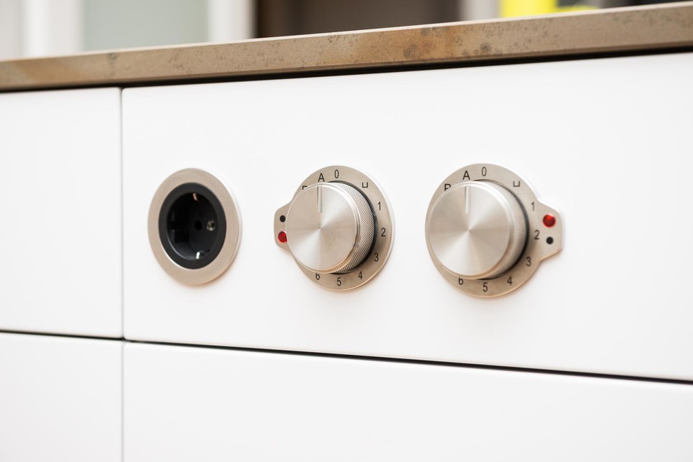 Offene, Einzeilige, Große Moderne Küche mit Unterbauwaschbecken, flächenbündigen Schrankfronten, weißen Schränken, Quarzit-Arbeitsplatte, Küchenrückwand in Weiß, Glasrückwand, Küchengeräten aus Edelstahl, braunem Holzboden, Kücheninsel, beigem Boden und brauner Arbeitsplatte in Berlin