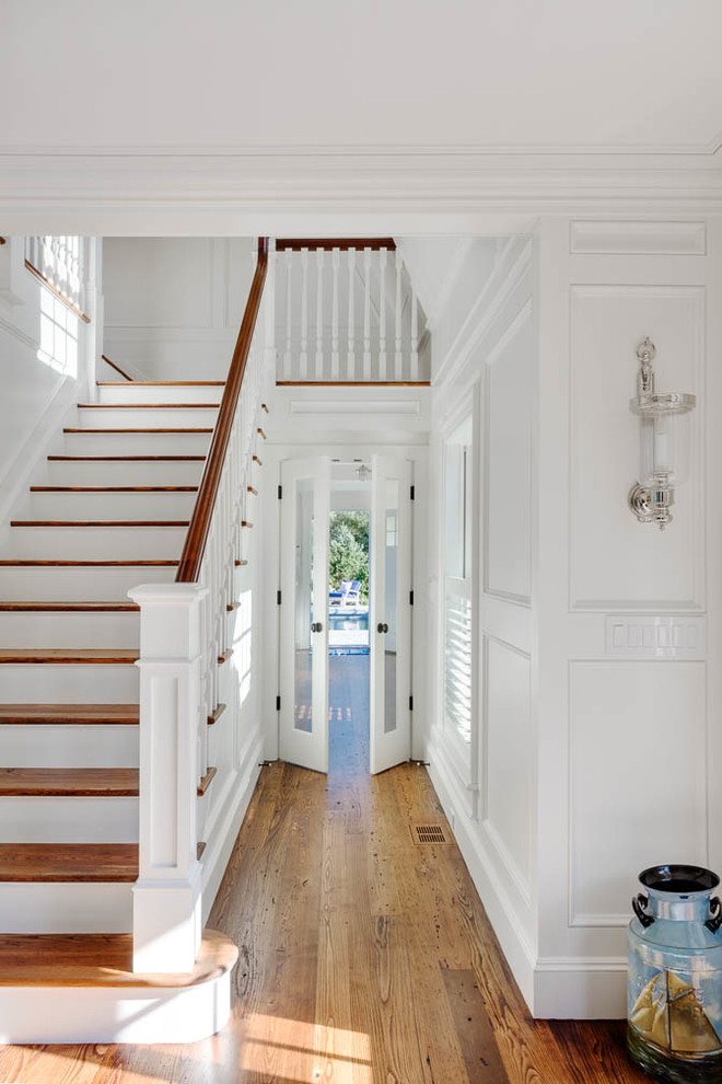 Design ideas for a large beach style mudroom in Boston with white walls and medium hardwood floors.