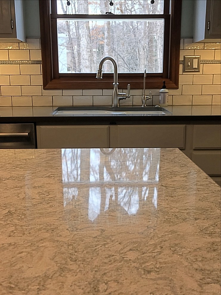 Enclosed kitchen - mid-sized transitional u-shaped medium tone wood floor enclosed kitchen idea with an undermount sink, white cabinets, quartz countertops, white backsplash, subway tile backsplash, stainless steel appliances and an island