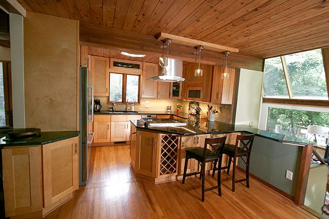 Inspiration for a small transitional l-shaped porcelain tile eat-in kitchen remodel with shaker cabinets, light wood cabinets, granite countertops, beige backsplash, glass tile backsplash, stainless steel appliances and a peninsula
