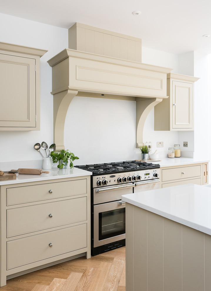 Inspiration for a mid-sized traditional l-shaped open plan kitchen in London with a farmhouse sink, shaker cabinets, green cabinets, marble benchtops, white splashback, marble splashback, stainless steel appliances, light hardwood floors, with island and yellow floor.
