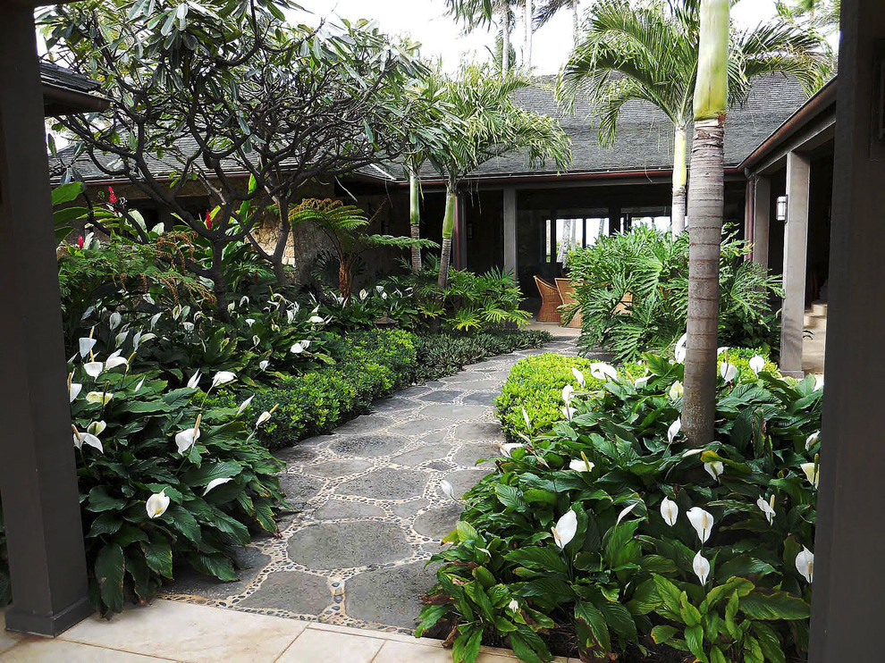 Photo of a mid-sized tropical courtyard shaded garden in Hawaii with natural stone pavers.