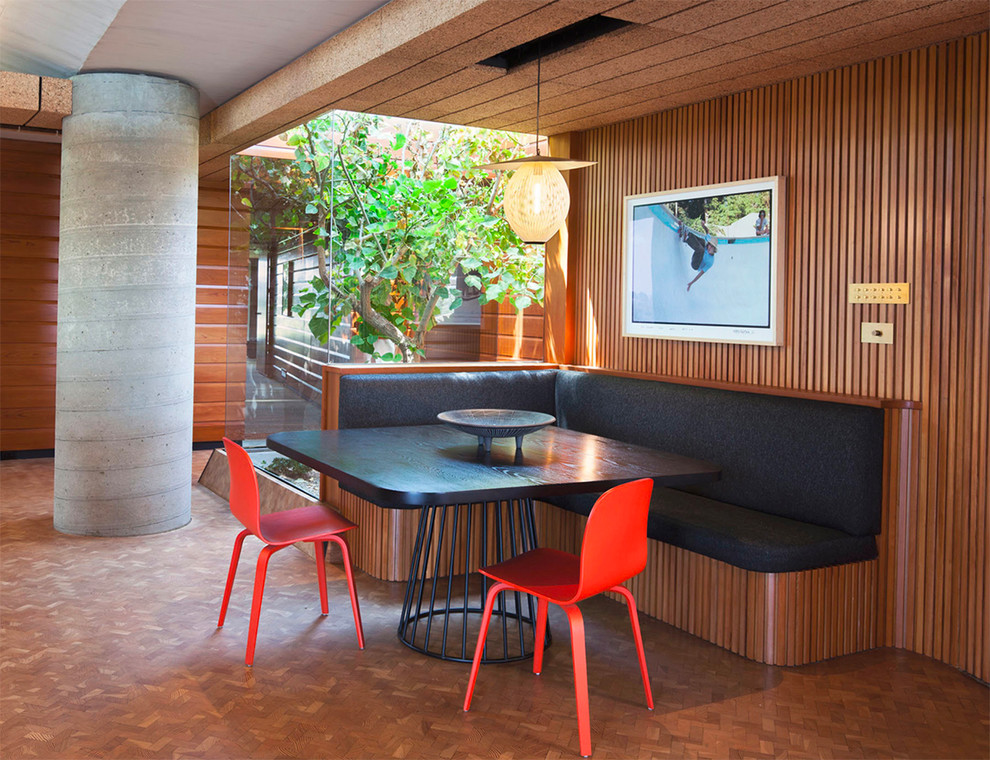 Small midcentury dining room in Los Angeles with brown walls, no fireplace and brown floor.