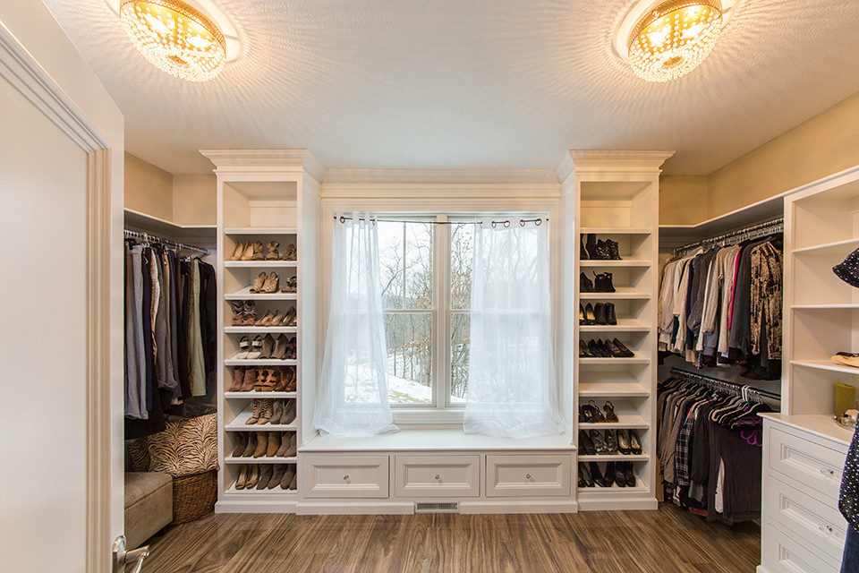 This is an example of a mid-sized arts and crafts gender-neutral walk-in wardrobe in Other with shaker cabinets, white cabinets, porcelain floors and brown floor.