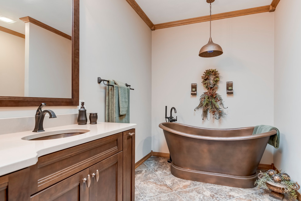 Design ideas for a traditional bathroom in St Louis with medium wood cabinets, a freestanding tub, a curbless shower, vinyl floors, an undermount sink, engineered quartz benchtops, a hinged shower door and beige benchtops.