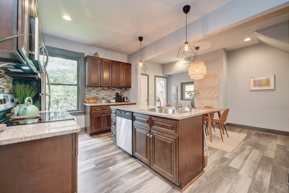 Inspiration for a mid-sized transitional l-shaped gray floor open concept kitchen remodel with a double-bowl sink, raised-panel cabinets, dark wood cabinets, granite countertops, gray backsplash, matchstick tile backsplash, stainless steel appliances, an island and beige countertops