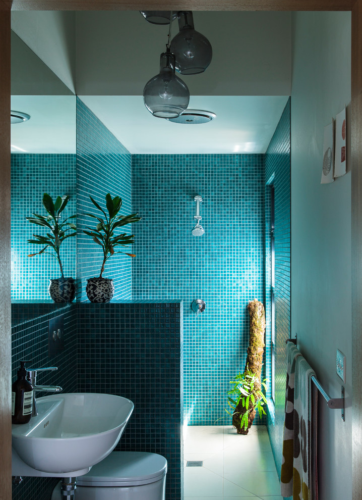 Inspiration for a small contemporary master bathroom in Melbourne with open cabinets, white cabinets, an open shower, a wall-mount toilet, green tile, mosaic tile, white walls, ceramic floors, a wall-mount sink and tile benchtops.