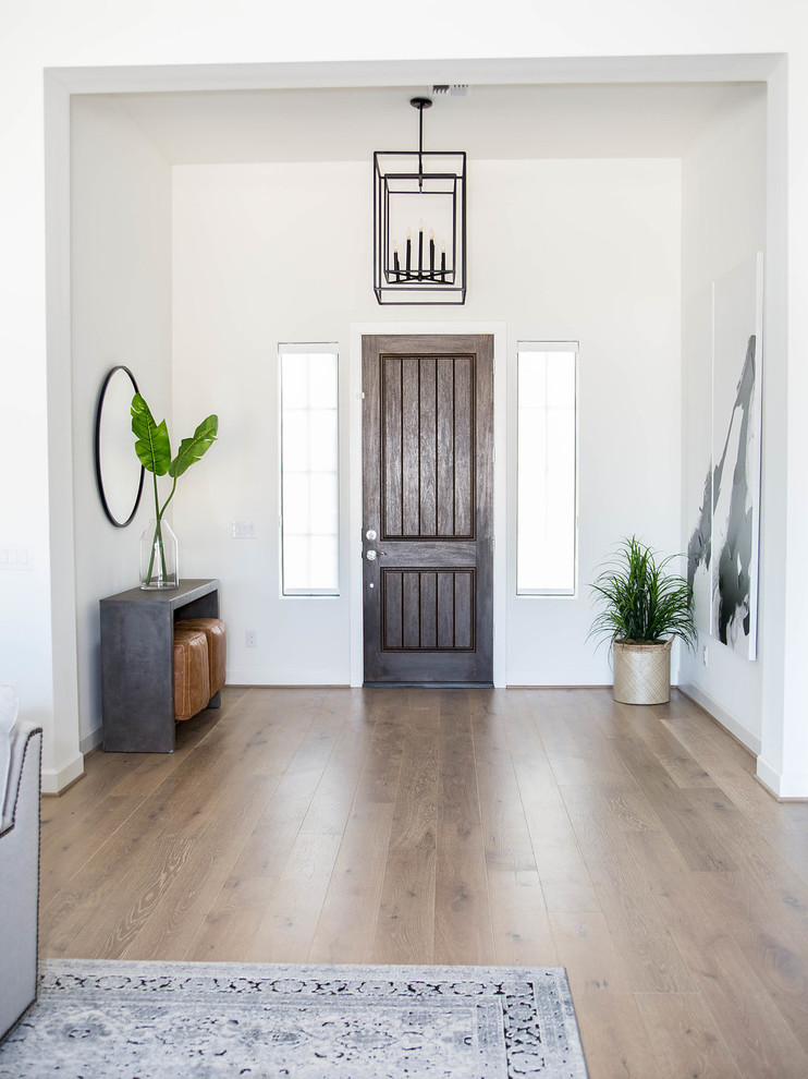 Foyer - large transitional light wood floor and yellow floor foyer idea in Phoenix with white walls and a black front door