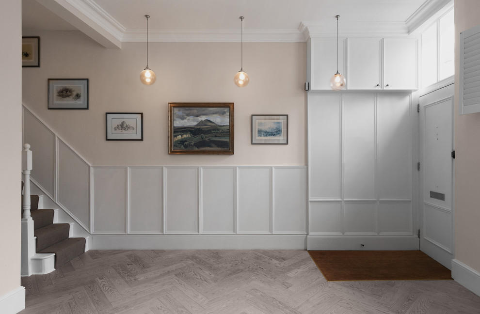 Photo of a mid-sized traditional entryway in London with beige walls, light hardwood floors and grey floor.