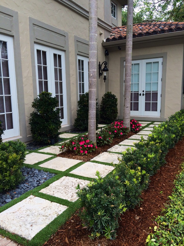 Large contemporary courtyard partial sun formal garden in Miami with natural stone pavers for summer.