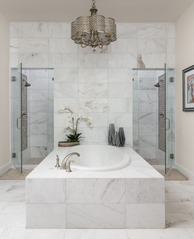 Photo of a mid-sized traditional master bathroom in Houston with a drop-in tub, a double shower and a hinged shower door.