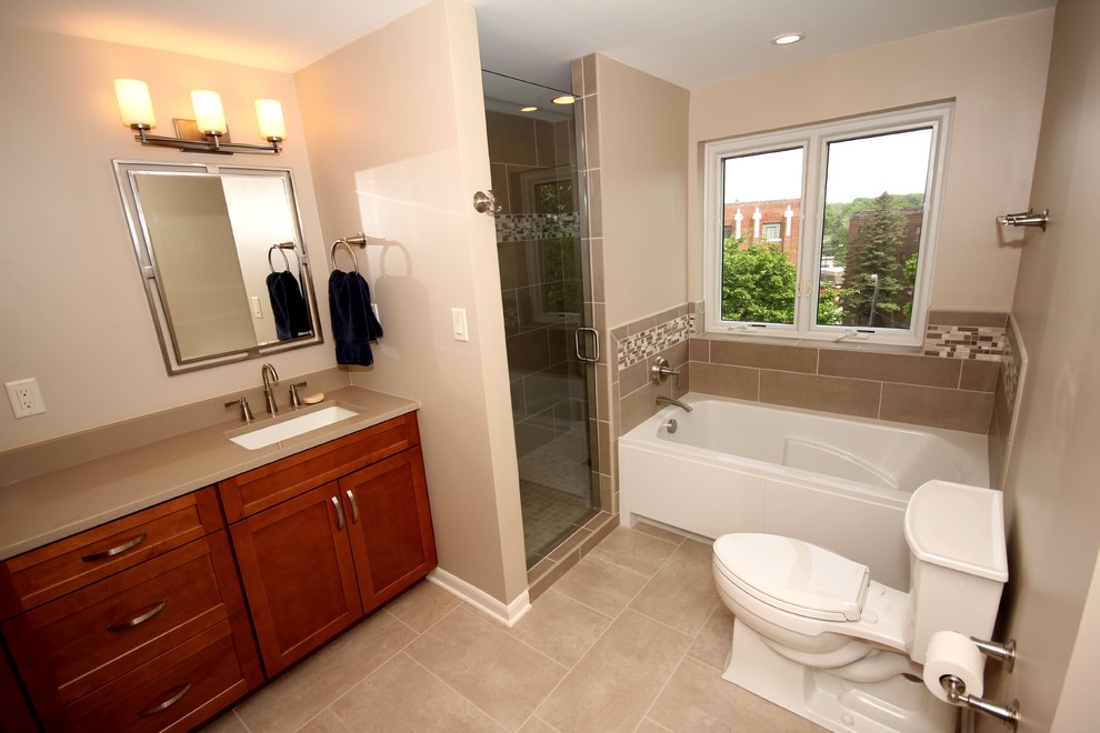 Inspiration for a mid-sized transitional master bathroom in Other with medium wood cabinets, ceramic tile, ceramic floors, quartzite benchtops, shaker cabinets, an alcove tub, a corner shower, a one-piece toilet, beige tile, beige walls and an undermount sink.