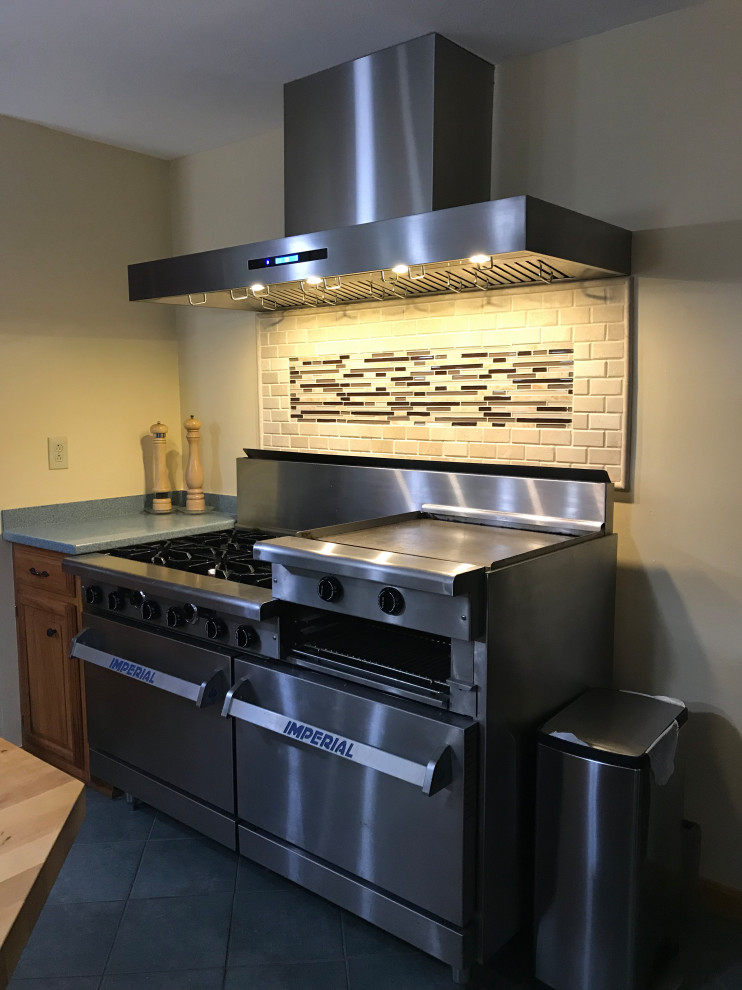 This is an example of a small single-wall eat-in kitchen in Salt Lake City with granite benchtops, multi-coloured splashback, ceramic splashback, stainless steel appliances, with island and green benchtop.