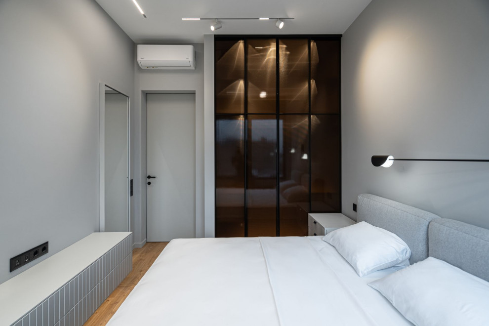 Пример оригинального дизайна: хозяйская спальня среднего размера, в светлых тонах в современном стиле с серыми стенами и паркетным полом среднего тона