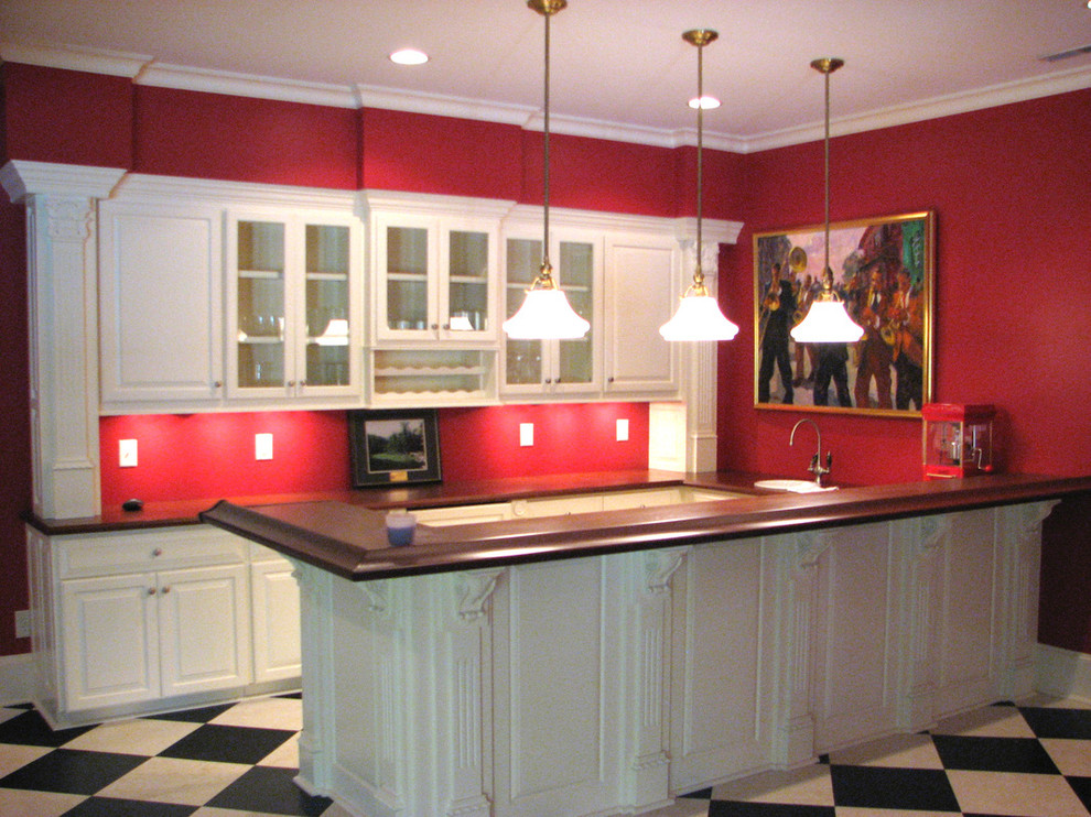 Photo of a mid-sized traditional galley seated home bar in Raleigh with a drop-in sink, raised-panel cabinets, white cabinets, solid surface benchtops and vinyl floors.