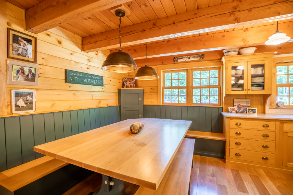 Photo of a country l-shaped eat-in kitchen in Portland Maine with with island, wood, exposed beam, shaker cabinets, light wood cabinets, white splashback, stainless steel appliances, light hardwood floors, beige floor, white benchtop, ceramic splashback and quartzite benchtops.