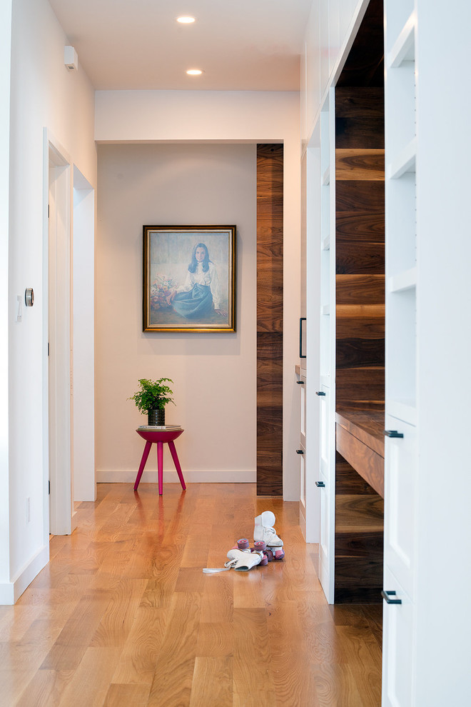 Design ideas for a mid-sized contemporary hallway in San Francisco with white walls, light hardwood floors and brown floor.