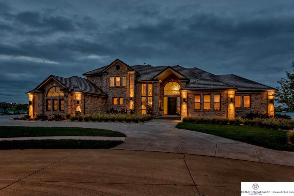 Design ideas for an expansive contemporary two-storey brick beige exterior in Omaha.