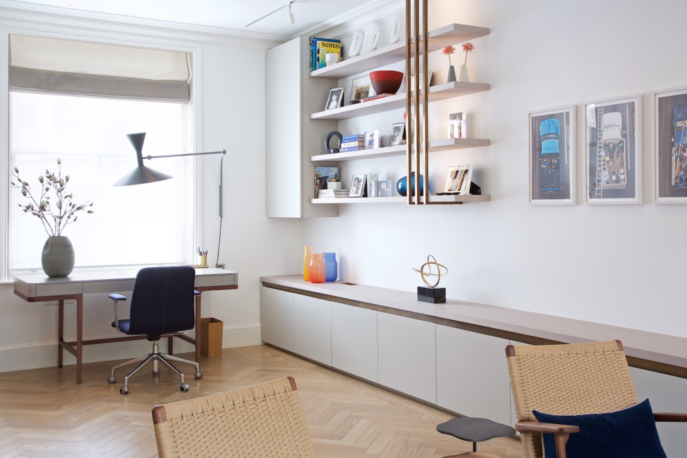 This is an example of a mid-sized contemporary study room in London with white walls, a freestanding desk and beige floor.