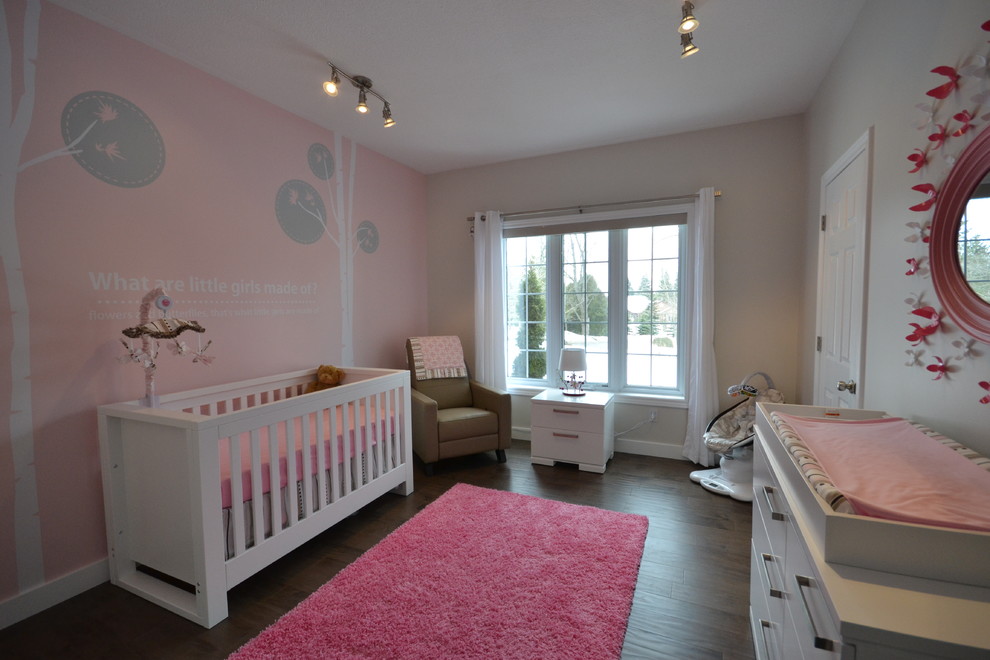 Modern nursery in Other with pink walls for girls.