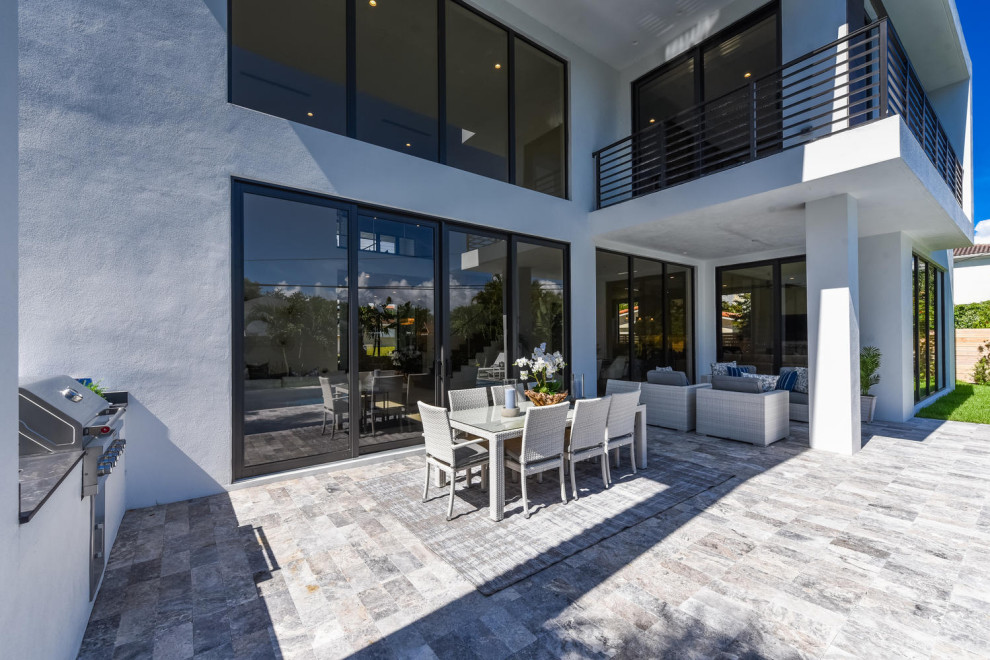 Пример оригинального дизайна: двор на заднем дворе в стиле модернизм с летней кухней, покрытием из плитки и навесом