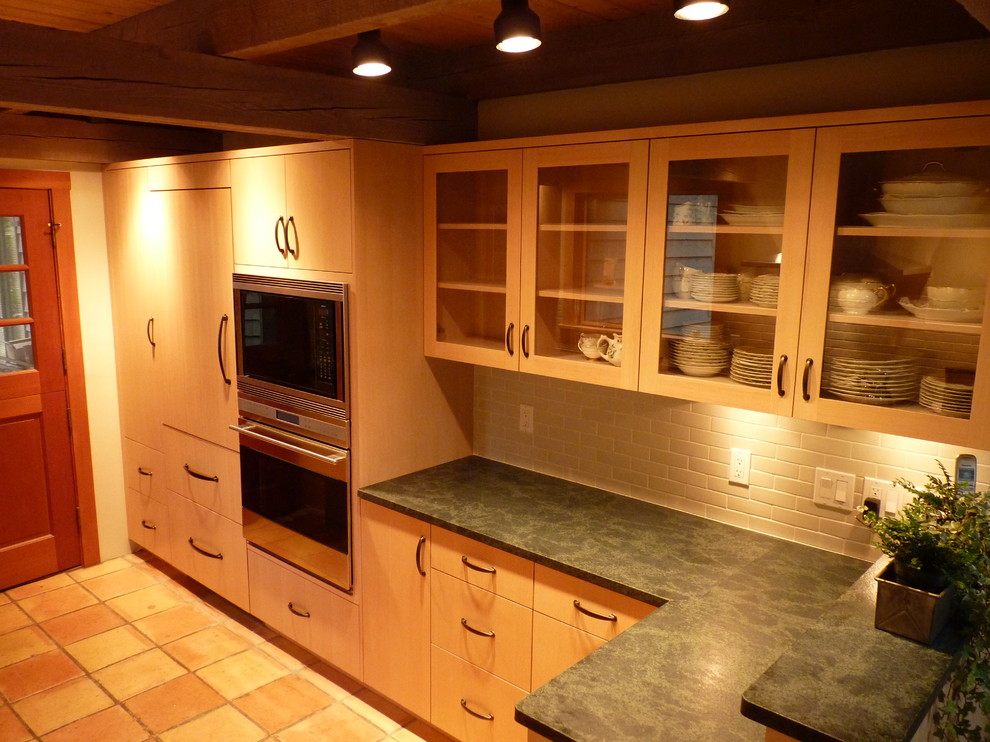 Inspiration for a transitional galley eat-in kitchen remodel in Seattle with an undermount sink, flat-panel cabinets, light wood cabinets, soapstone countertops, gray backsplash, porcelain backsplash and paneled appliances