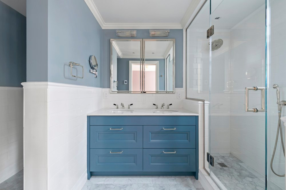 Inspiration for a medium sized classic ensuite bathroom in New York with recessed-panel cabinets, blue cabinets, an alcove shower, white tiles, ceramic flooring, a built-in sink, engineered stone worktops, grey floors, a hinged door, white worktops, double sinks and a freestanding vanity unit.