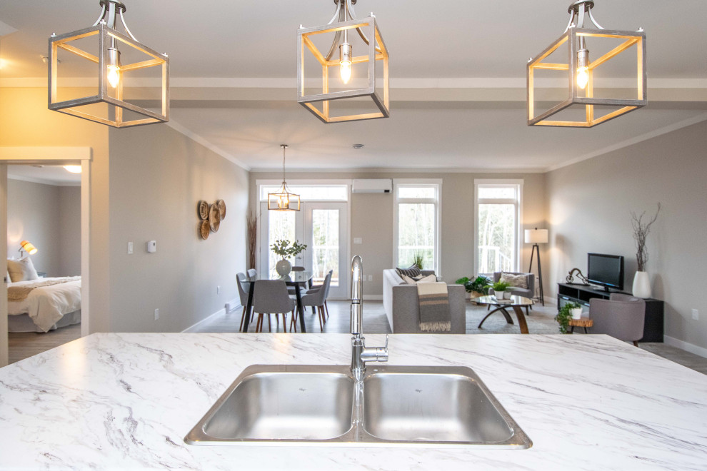 Mid-sized beach style galley vinyl floor, beige floor and vaulted ceiling open concept kitchen photo in Other with a double-bowl sink, shaker cabinets, brown cabinets, laminate countertops, white backsplash, ceramic backsplash, an island and multicolored countertops