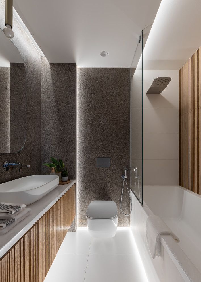 Inspiration för mellanstora moderna vitt en-suite badrum, med luckor med lamellpanel, skåp i mellenmörkt trä, ett undermonterat badkar, en dusch/badkar-kombination, en vägghängd toalettstol, beige kakel, keramikplattor, grå väggar, klinkergolv i porslin, bänkskiva i akrylsten, vitt golv och dusch med duschdraperi
