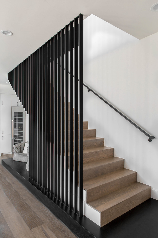 Inspiration for a contemporary wood straight staircase in Austin with wood risers and metal railing.