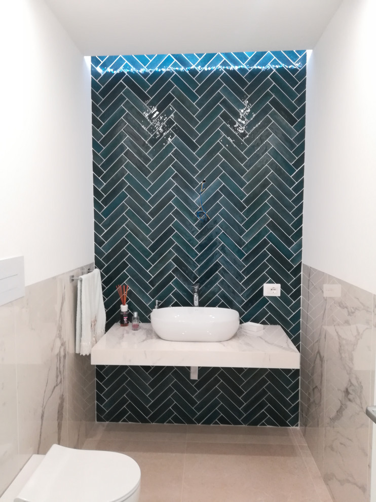 Пример оригинального дизайна: туалет среднего размера: освещение в стиле модернизм с синей плиткой, керамогранитной плиткой, белыми стенами, полом из керамогранита, мраморной столешницей, бежевым полом и подвесной тумбой