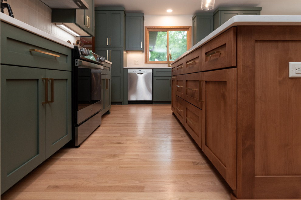 Inspiration for a transitional light wood floor kitchen remodel with shaker cabinets, green cabinets, quartz countertops, white backsplash, ceramic backsplash and an island