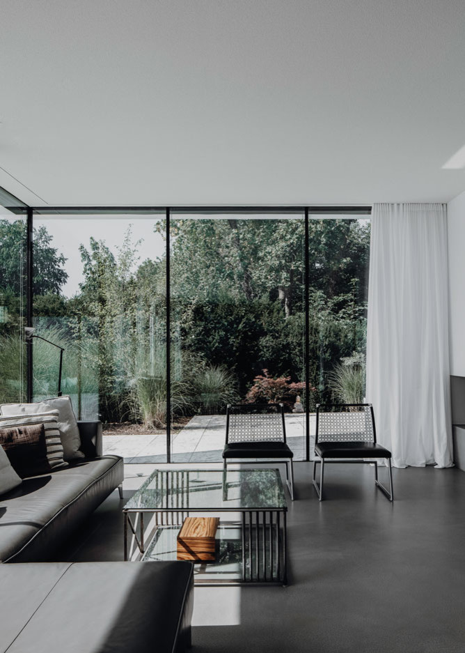 Inspiration for an expansive modern formal open concept living room in Munich with white walls, concrete floors, a wood stove, a plaster fireplace surround, no tv and grey floor.