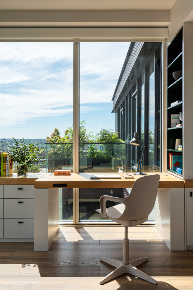Inspiration pour un bureau design de taille moyenne avec un mur gris, un sol en bois brun, un bureau intégré et un sol marron.