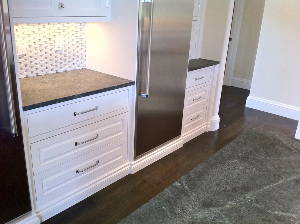 Example of a large transitional u-shaped dark wood floor and brown floor open concept kitchen design in Miami with a farmhouse sink, shaker cabinets, white cabinets, granite countertops, multicolored backsplash, stone tile backsplash, stainless steel appliances and an island