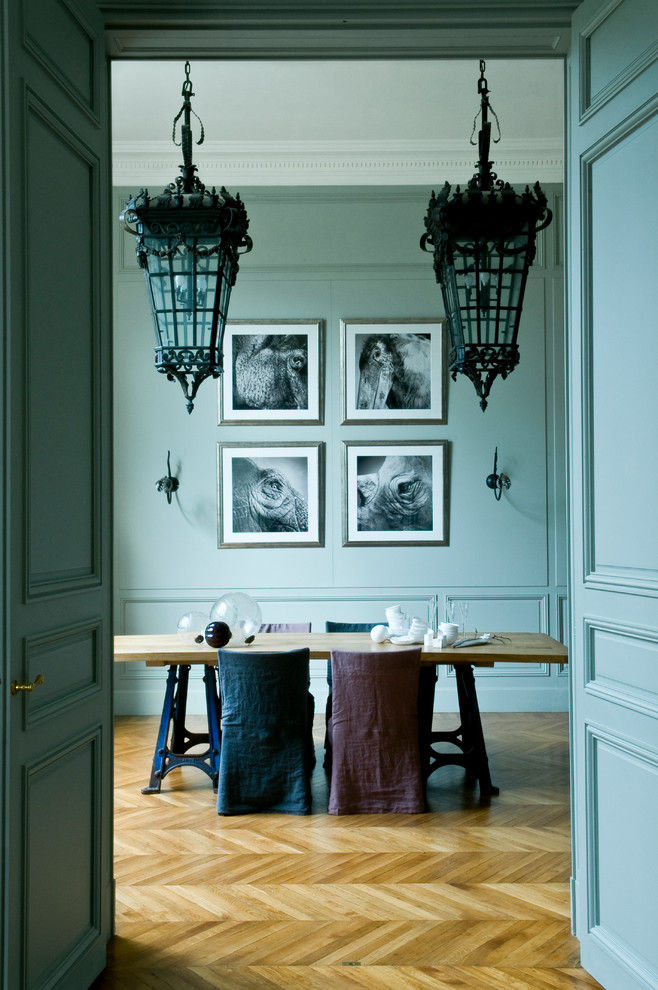This is an example of a mid-sized eclectic open plan dining in Paris with blue walls, light hardwood floors, no fireplace and beige floor.