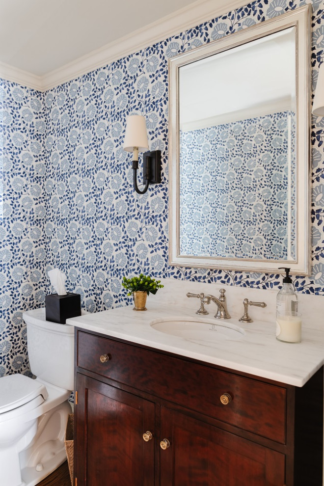 Immagine di un bagno di servizio chic con ante in legno bruno, WC monopezzo, pareti blu, top bianco e carta da parati