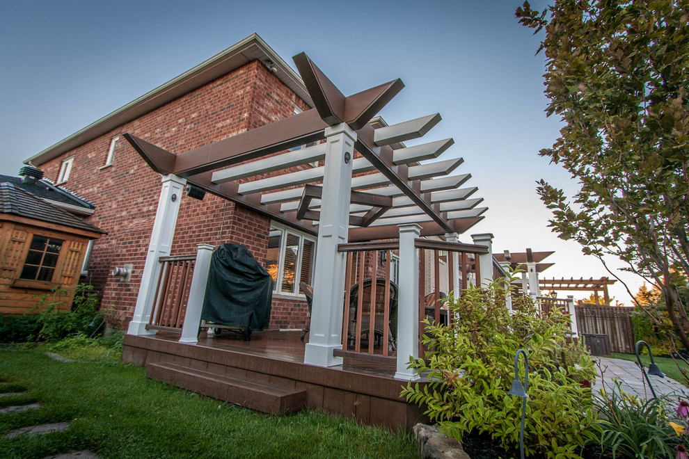 Photo of a mid-sized traditional backyard deck in Toronto with a pergola.