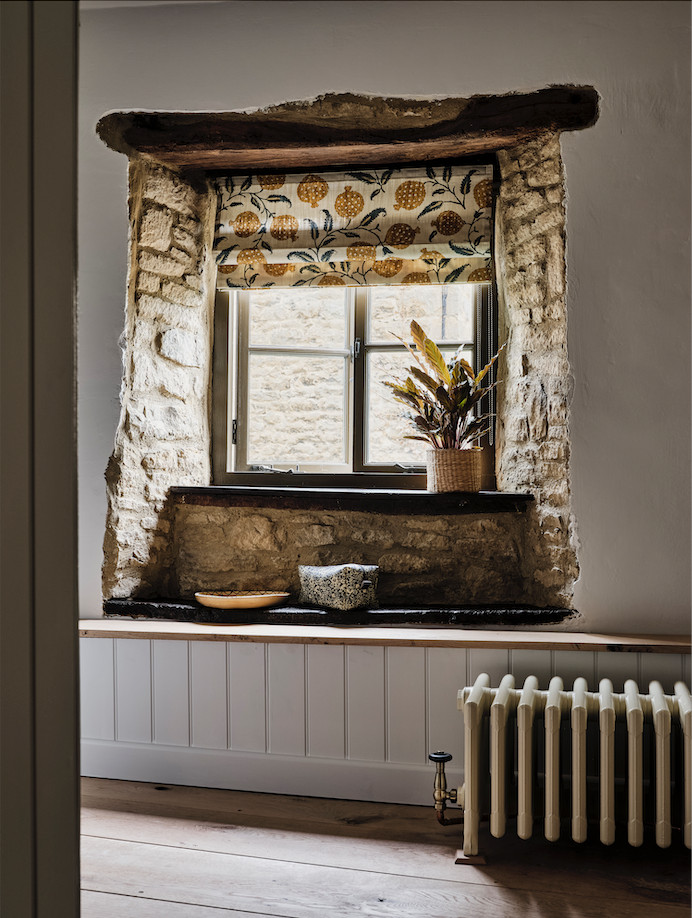 Inspiration for a mid-sized country 3/4 bathroom in Oxfordshire with a curbless shower, a wall-mount toilet, brown tile, white walls, medium hardwood floors, a wall-mount sink, brown floor, a sliding shower screen, a single vanity and planked wall panelling.