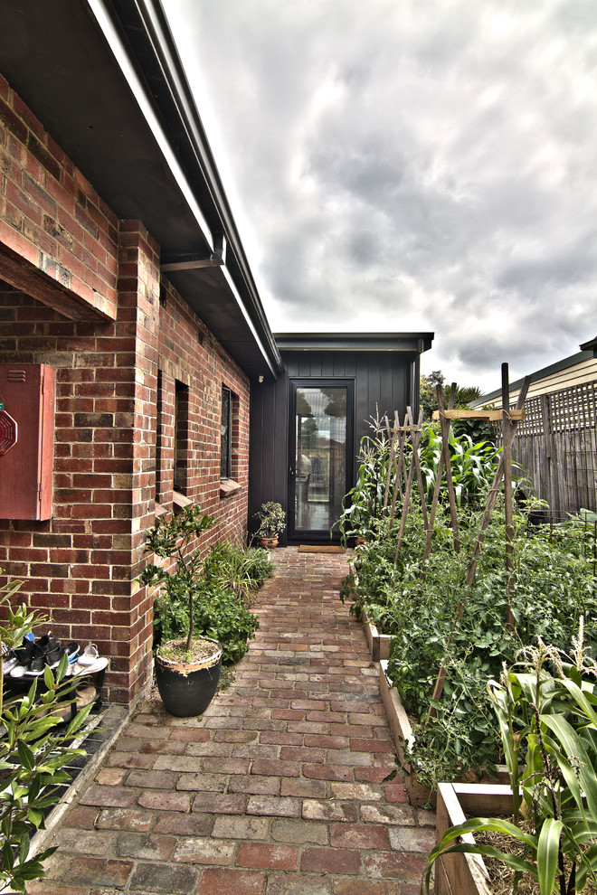Mid-sized industrial one-storey black exterior in Melbourne with metal siding and a flat roof.