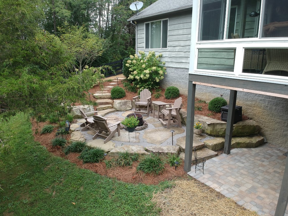 Inspiration for a mid-sized rustic backyard stone patio remodel with a fire pit and no cover